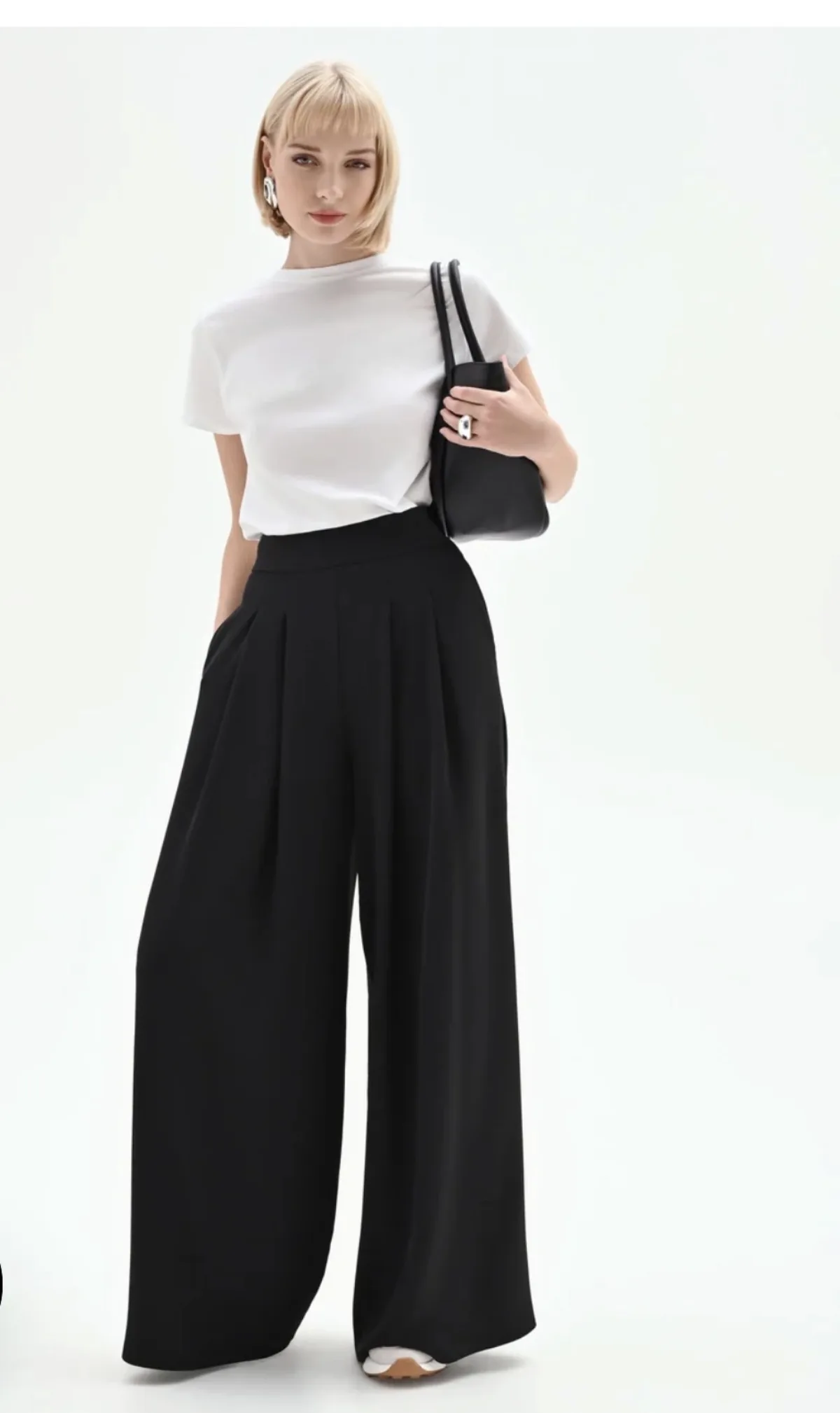Dames look — wit T-shirt met zwarte wide-leg pleated broek en zwarte tas